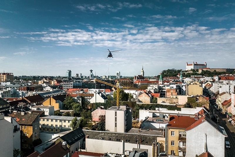 Un elicottero trasporta una gru Liebherr nel centro di Bratislava